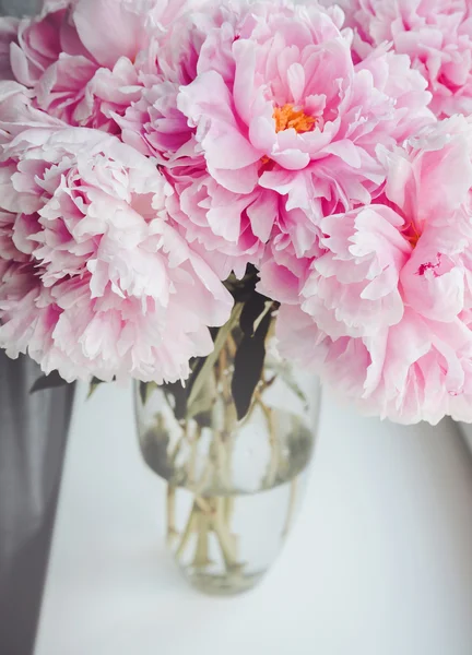 Beautiful bouquet of pink peonies, peony roses flowers in vase on white window sill, pastel color background. Spring or summer lovely nosegay. Fresh floral, home decor. Trend  . Text, copy space