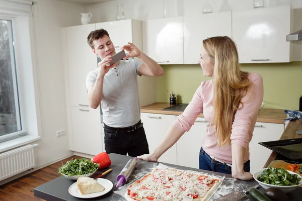 Couple preparing the pizza in the kitchen