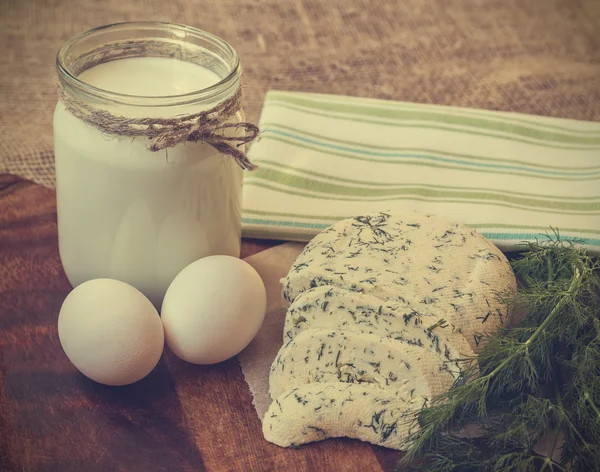 Vintage photo of homemade cheese with dill, milk and eggs