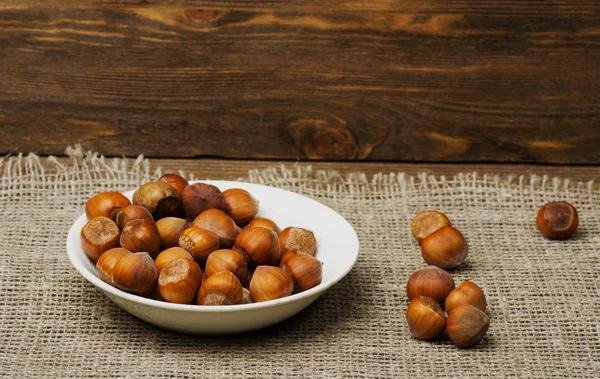 Pile of hazelnuts in shell on wooden table