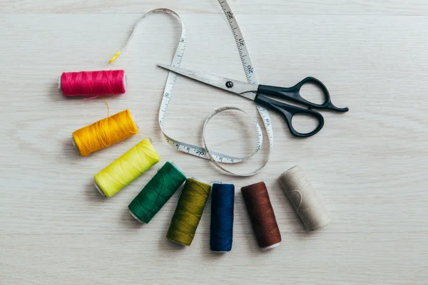 Meter tape, scissors and multicolored sewing spools