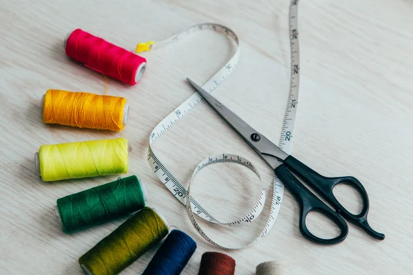 Meter tape, scissors and multicolored sewing spools