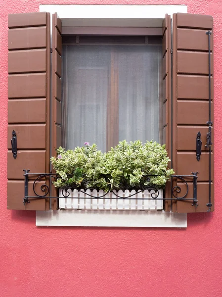Burano, Italy - 21 May 2015: Red painted building. Close up of w