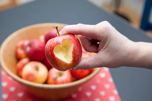 Hand holding apple with cutout heart shape