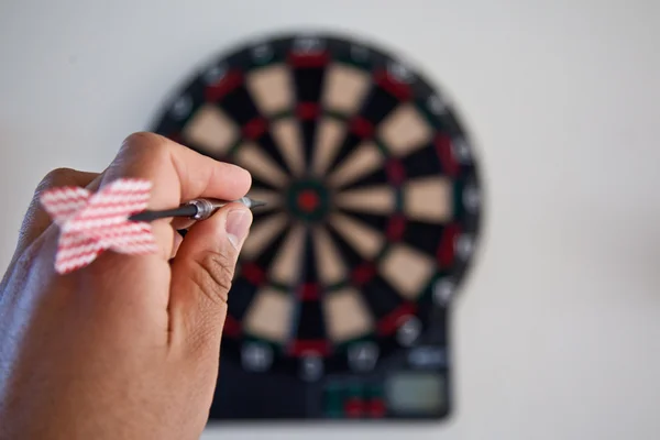 Hand with dart and dart board