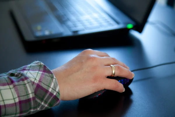 Woman hand on mouse at laptop