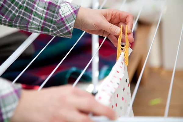 Woman hanging laundry to laundry stand