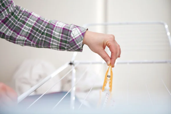 Woman hanging laundry to laundry stand