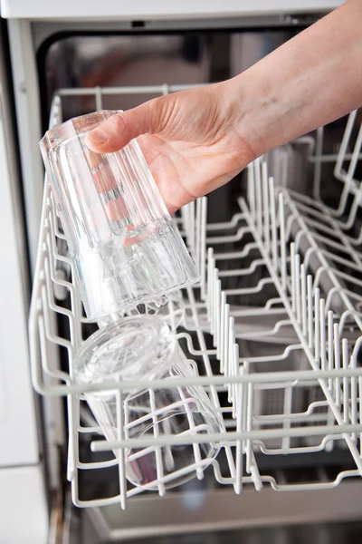 Woman putting glass in the dishwasher