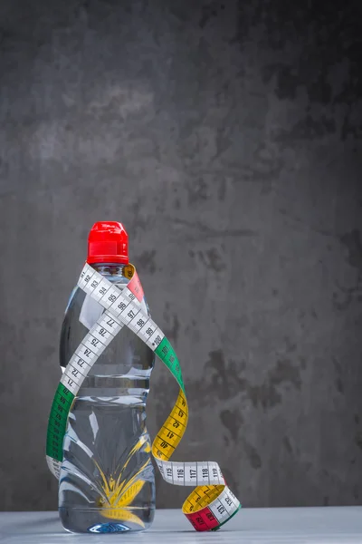 Bottle of fresh still water with measuring tape