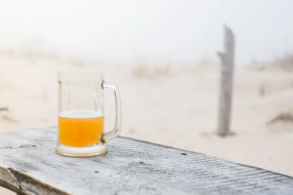 Mug with wheat beer on the bench
