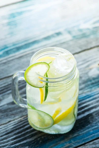 Jar with infused detox water on wooden table