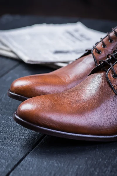 Brown leather shoes on black floor