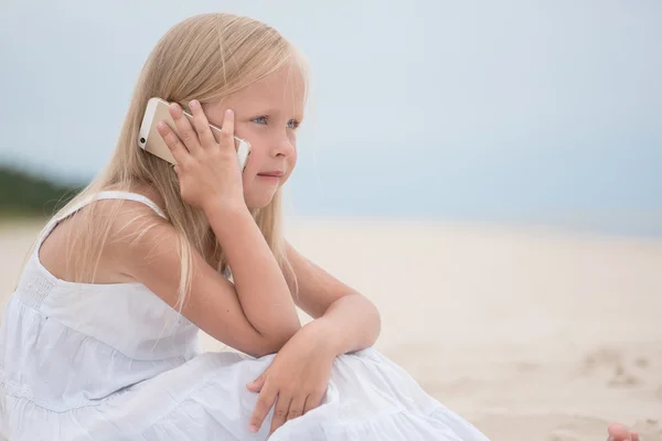 Beautiful young girl talking on the phone at the seaside