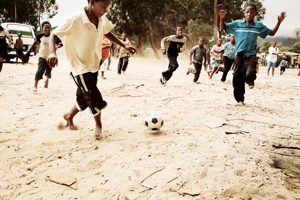 Children playing soccer in township, South Africa.