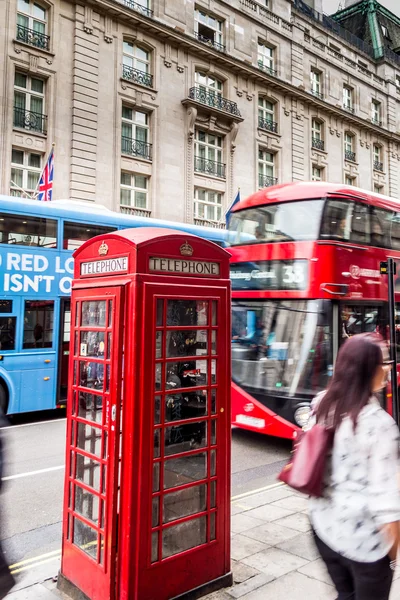 Red telephone box with red bus