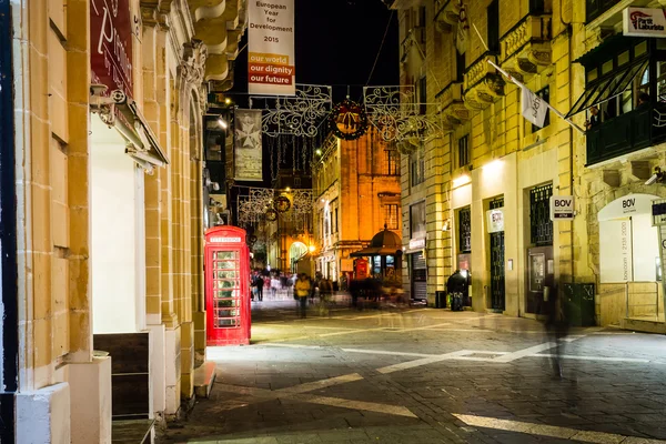 Red telephone box on Republic Street Valletta Malta by night