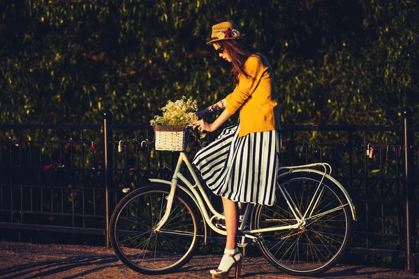 Young beautiful, elegantly dressed woman with bicycle. Beauty, fashion and lifestyle