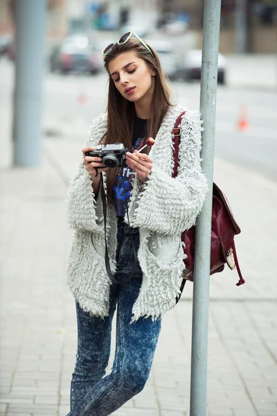 Young street fashion girl on the background of old brick wall. Outdoors, lifestyle.