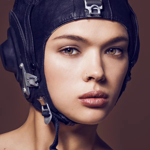 Woman in black helmet and professional makeup close up portrait