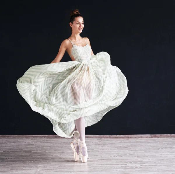 Portrait of the modern ballerina  in white dress on dark background