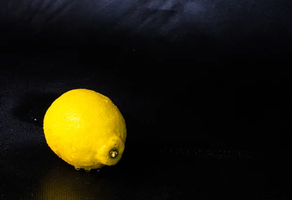 Studio shot of single lemon isolated on black background