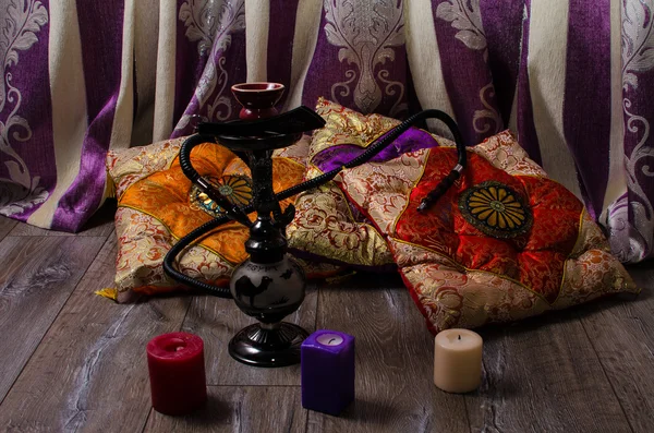 Hookah on a background of oriental cushions and candles