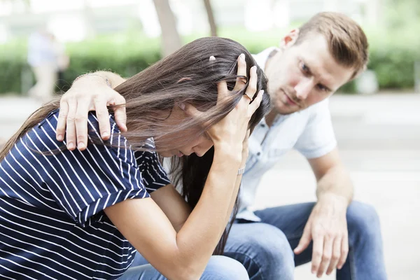 Side view of a man comforting a sad caucasian girl mourning