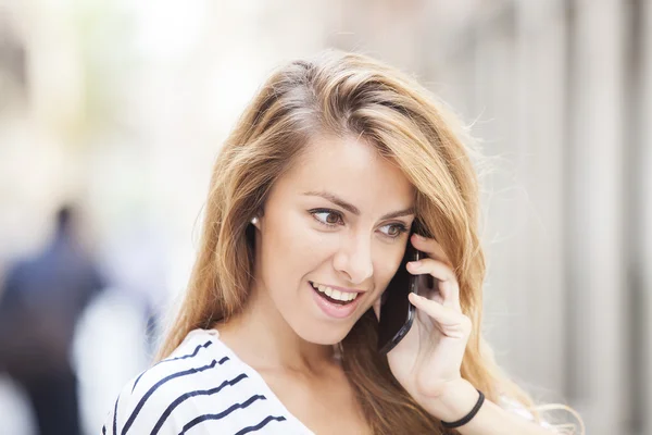 Cheerful woman talking on the phone in the street