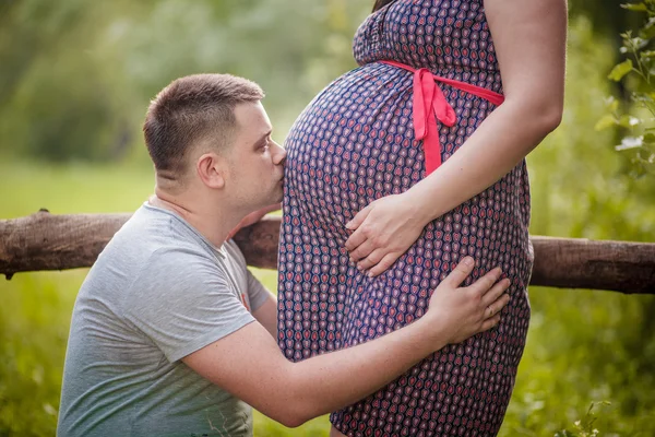Man is kissing pregnancy belly of his wife