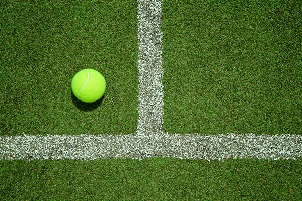 Tennis ball near the line on tennis grass court good for backgro