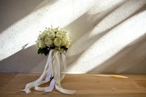 White rose wedding bouquet at the wall with shadow