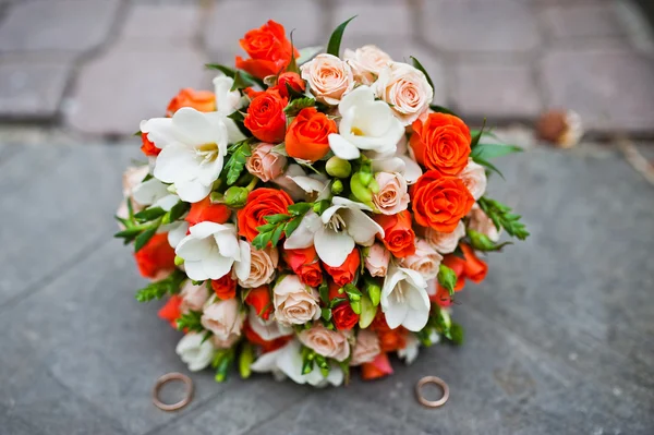 Wedding bouquet of white and orange roses and with two wedding r