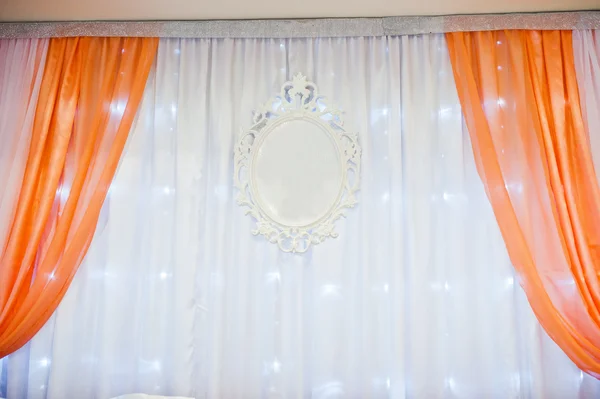 Orange curtains and chairs at table of newlyweds on wedding part