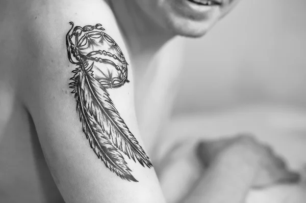 Close up tattoo Dreamcatcher at hand of man. Black and white pho