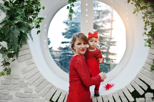 Mom and daugter at red dress background circle window with a bri
