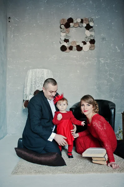 Happy family with daughter read the old book on rugs background