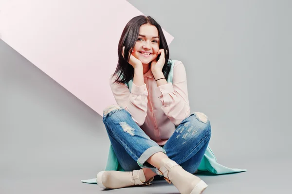 Full length studio portrait of young girl model at ripped jeans