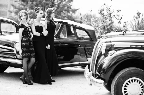 Three young girl in retro style dress near old classic vintage c