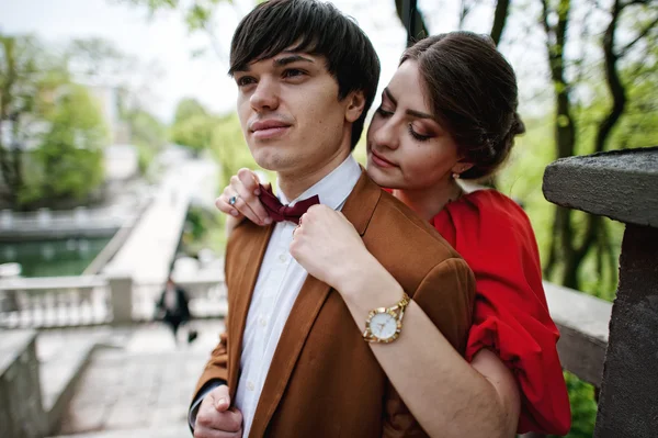 Close up portrait of couple. Girl hold hands on bow tie of her b