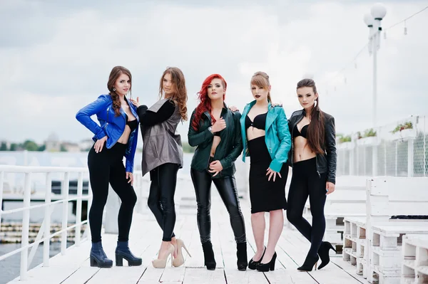 Group of sexy models girls in black bra and leather jackets on t