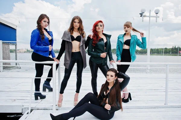 Group of sexy models girls in black bra and leather jackets on t