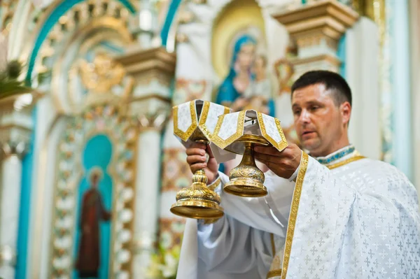 Mukyluntsi , Ukraine - 26 june, 2016: Priest with holy communion