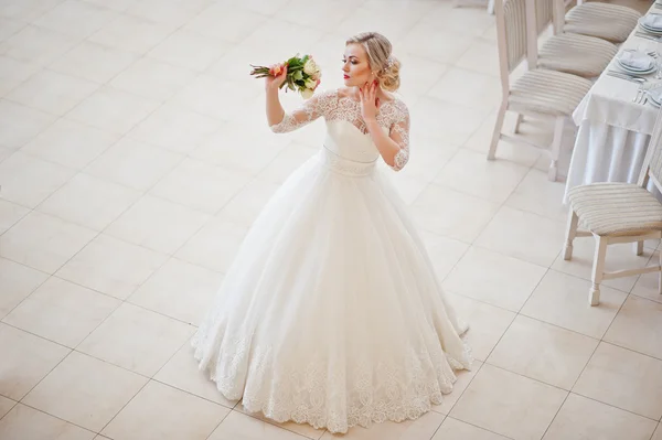 Gorgeous blonde bride posed indoor great wedding hall