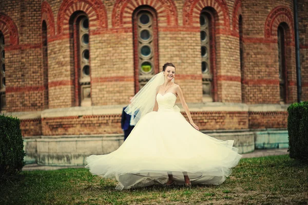 Bride dance with her dress near vintage building