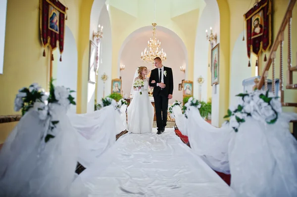 Wedding couple walking at church with white decoration
