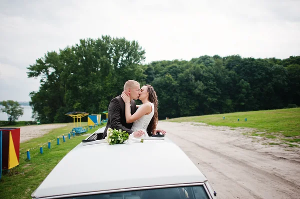 Couple kissing at the car sunroof