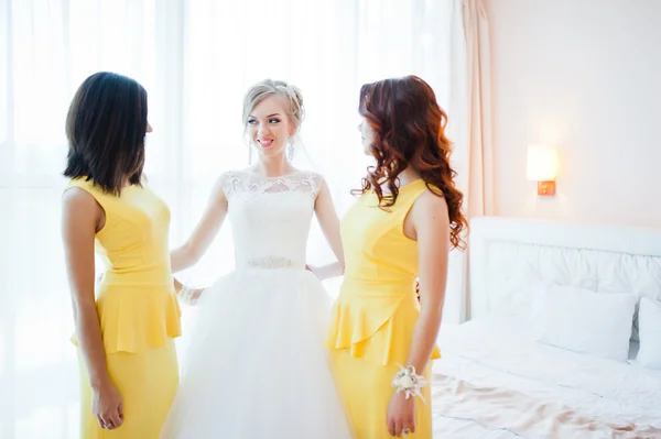 Gentle blonde  bride with bridesmaids at yellow dress