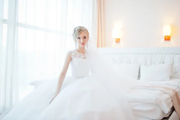 Gentle blonde  bride on couch tenderly posed
