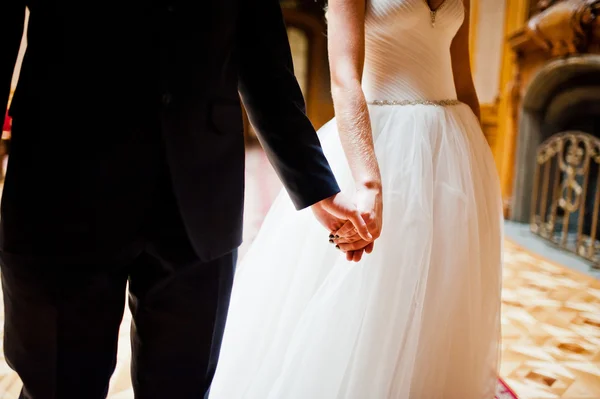 Hand in hand of elegant wedding couple at old vintage house and